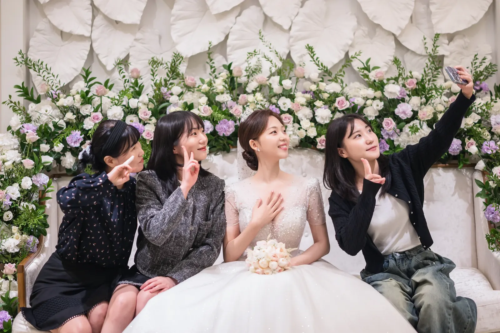 친구와 결혼식사진 예시 — 서울 공덕 아펠가모 신부대기실 꽃장식 소파에서 친구들과 셀카를 찍는 신부