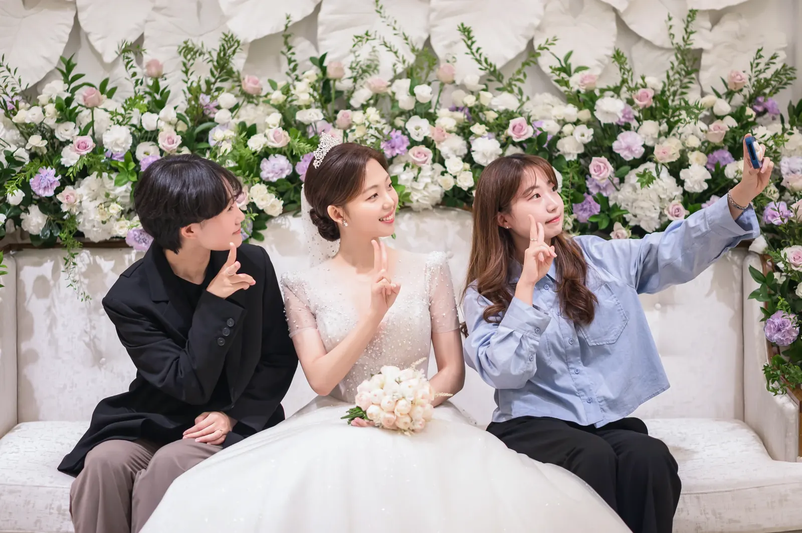 가까운 친구와의 결혼식사진 — 서울 공덕 아펠가모 꽃장식 소파에 앉아 브이를 그리는 신부와 친구들