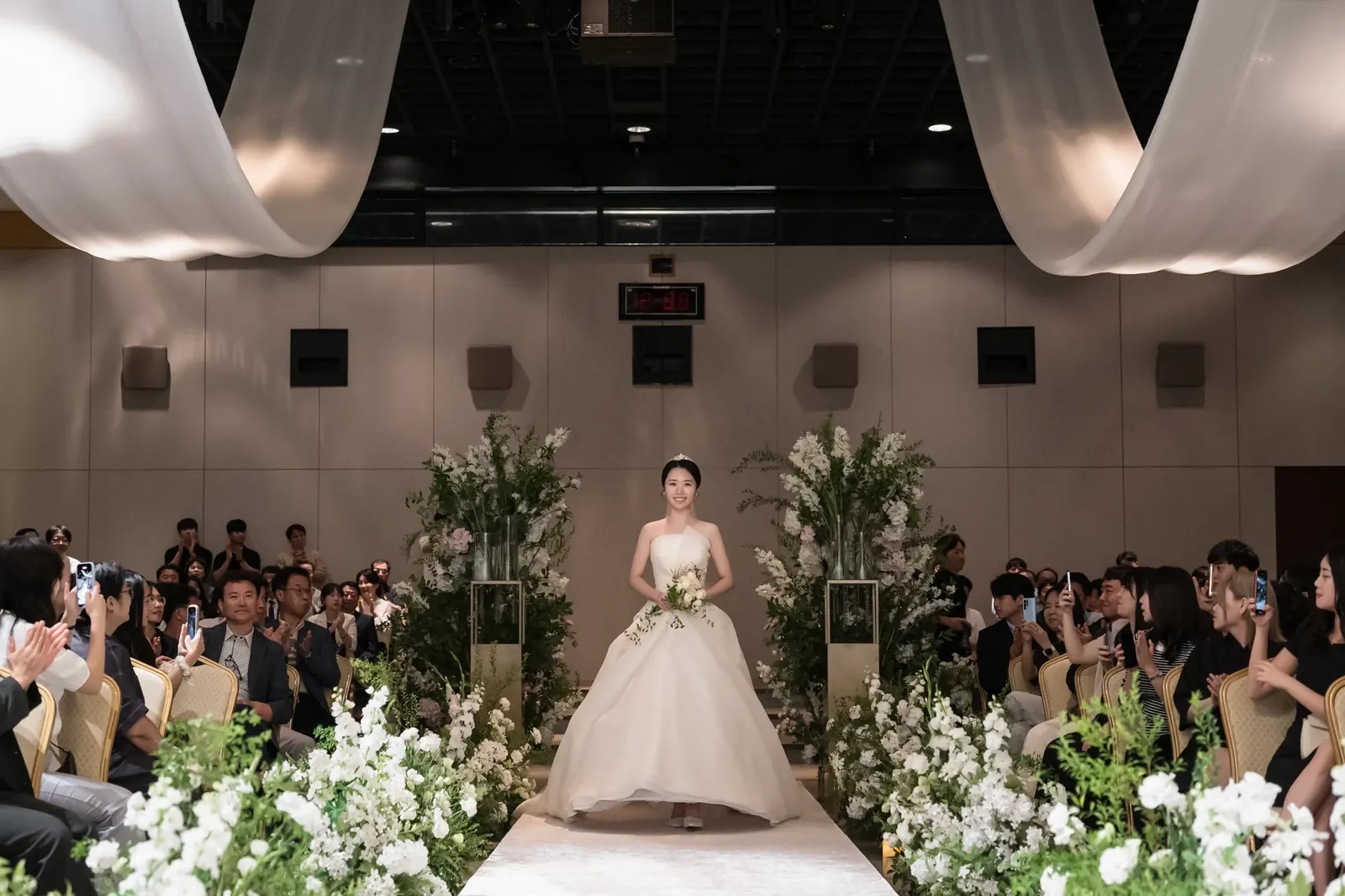 입장 사진 예시 — 서울 포스코컨벤션 하객석 사이 버진로드로 정면을 보며 걸어 들어오는 신부
