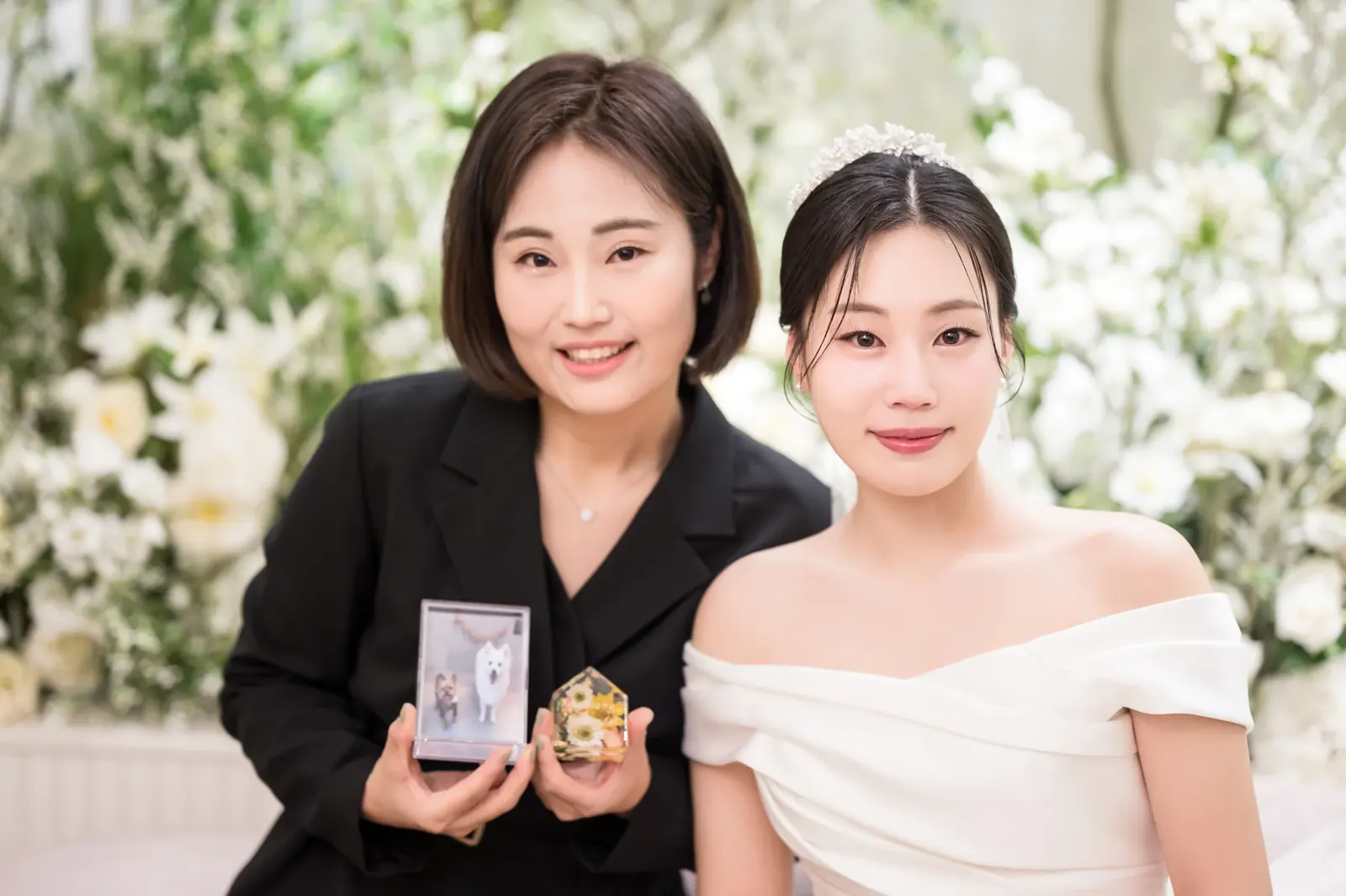세인트메리엘 결혼식사진 — 대기실에서 작은 액자 선물을 든 지인과 나란히 웃는 신부