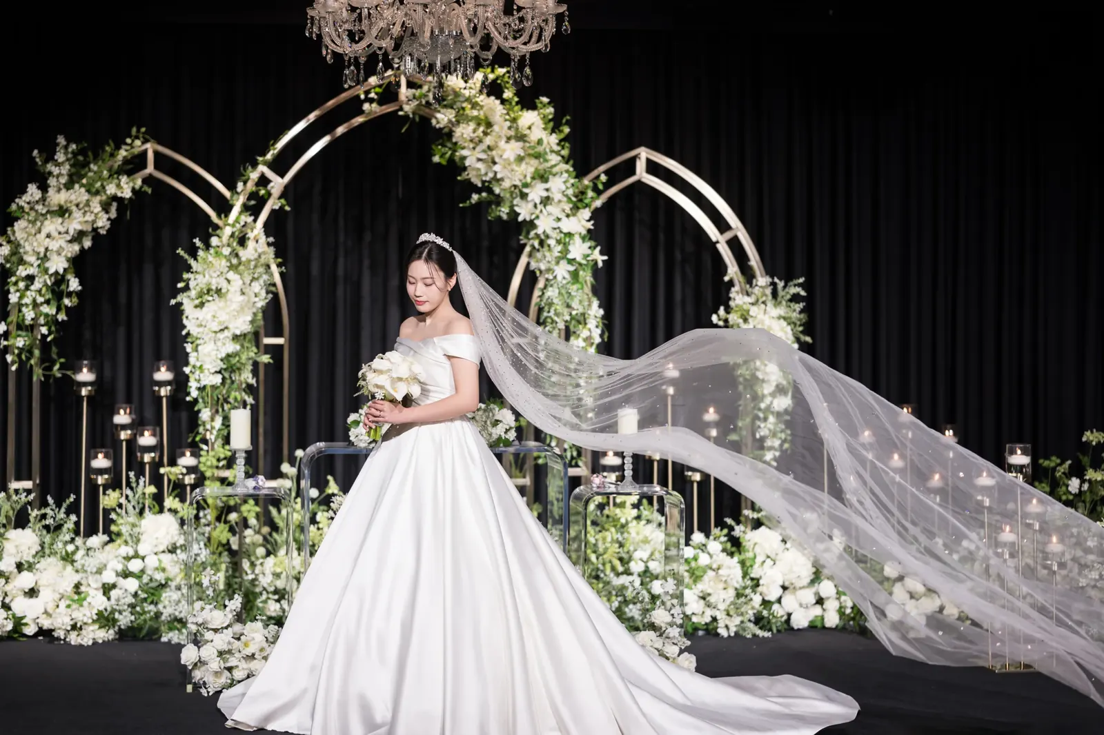 세인트메리엘 결혼식사진 — 꽃 아치 단상 앞에서 베일을 길게 날리는 신부