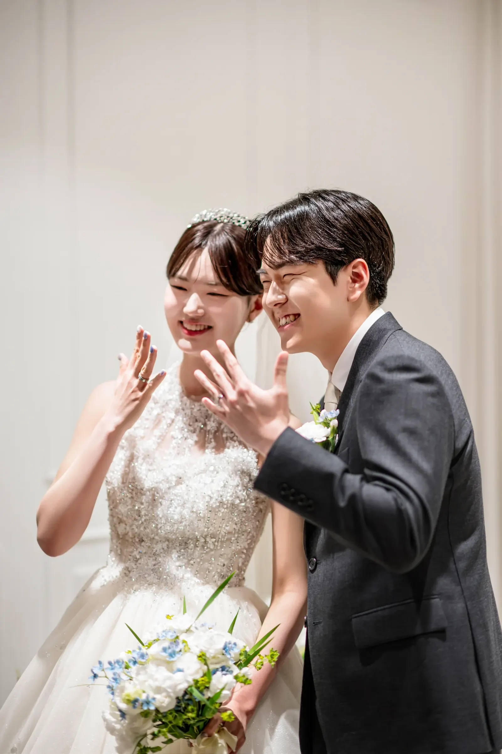 가까운 거리에서 담은 결혼식사진 — 서울 서초구 삼성금융캠퍼스에서 반지 낀 손을 흔들며 웃는 신랑 신부