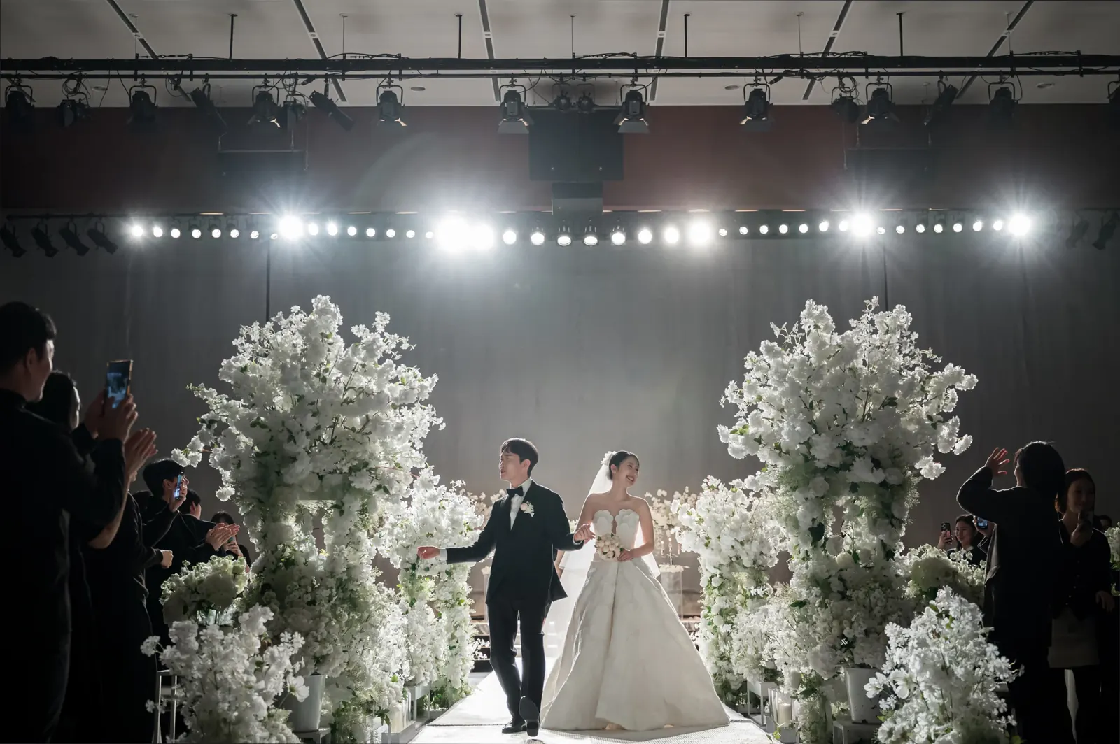 결혼식사진 비용 안내 — 서울 삼성서초사옥 본식에서 꽃 기둥 사이로 걸어 나오는 신랑 신부, 원판 종료까지 기본 촬영