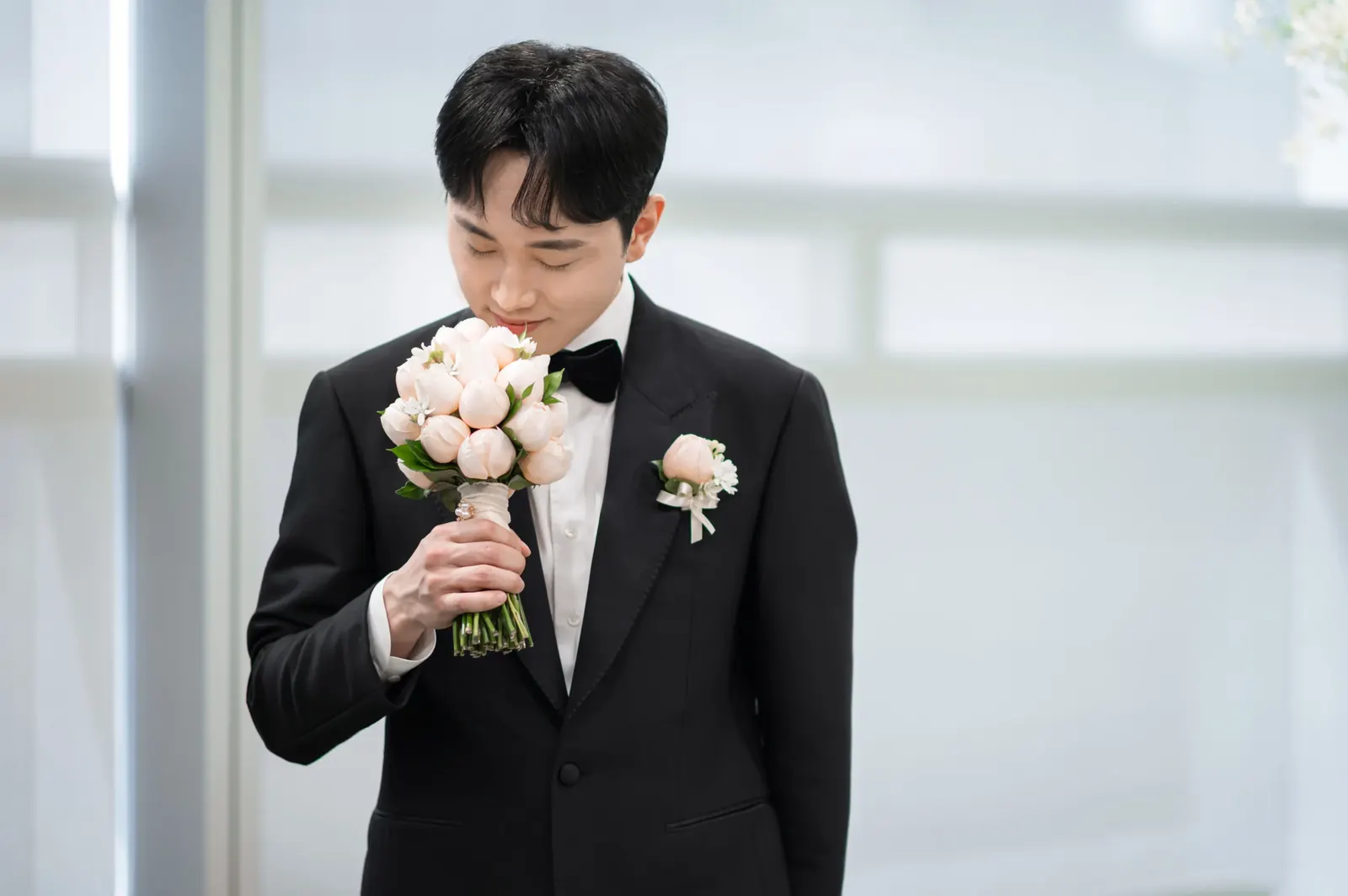 삼성서초사옥 결혼식사진 — 밝은 창가에서 부케 향을 맡으며 웃는 신랑